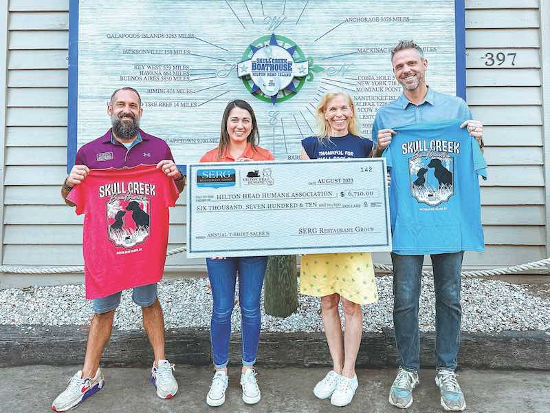 SERG Group partners Mike Marignoni and Chris Spargur and SERG retail director Katherine Lopez present a check to Franny Gerthoffer of Hilton Head Humane