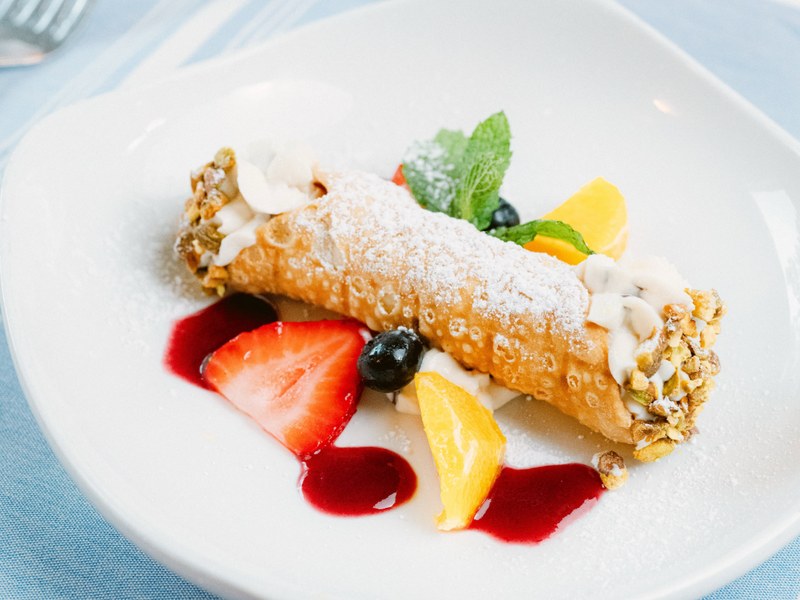 Cannolo Siciliano filled with ricotta, chocolate, orange zest and pistachio