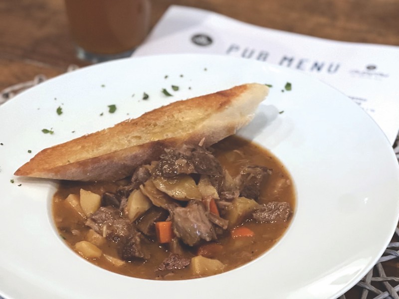 Irish Stew in white bowl with piece of bread