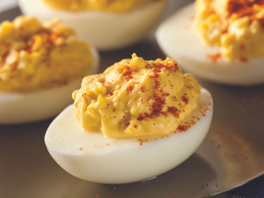 Deviled Eggs with paprika and placed on a wooden tray