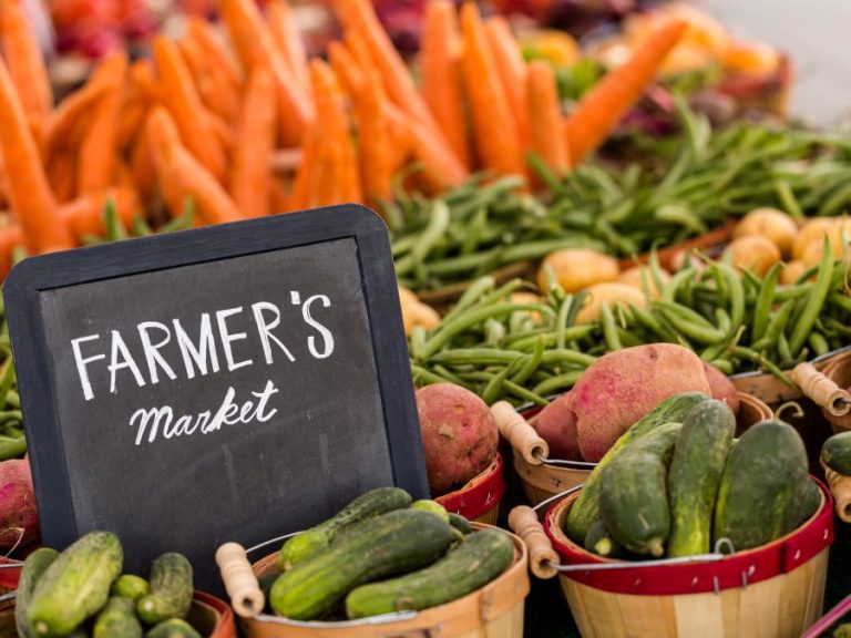 Farmers Market chalkboard sign with fresh produce in baskets