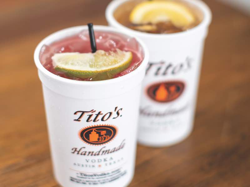 Two Titos Drinks in tito's cups with fruit garnish