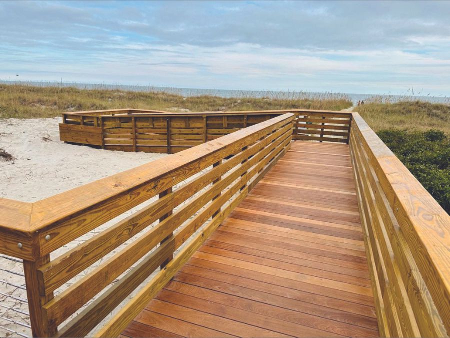 Boardwalk with sand in the background at the beach with blue skies