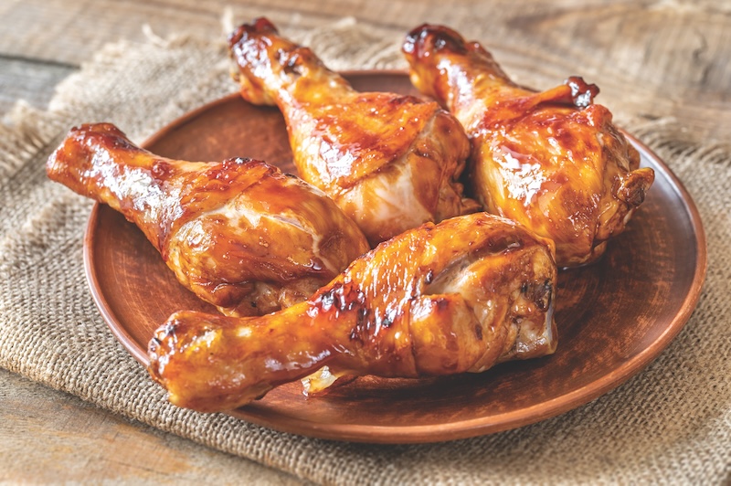 Grilled chicken drumsticks on a plate flat lay