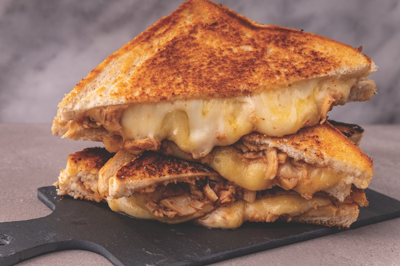 Four stacked servings of chicken and melted cheese sandwich