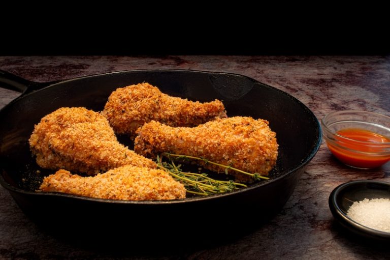 Plate of fried chicken legs in a cast iron skillet.