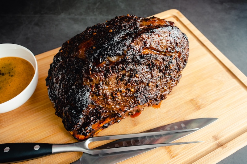 Spice Rubbed Bone-in Standing Prime Rib Roast: Roast beef with au jus sauce before being carved