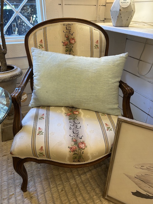 Antique cushioned arm chair at Antiques & Garden Collectibles on Hilton Head Island.