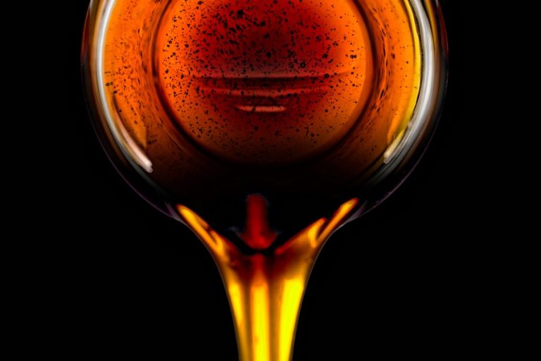 Pouring sorghum syrup on black background
