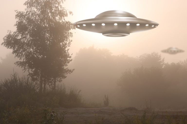 Photoshopped image of two UFOs hovering over Lowcountry landscape with tree in foreground