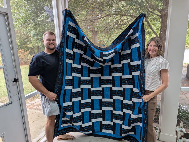 Laura Williams holds up her quilt Palmetto Quilters Guild