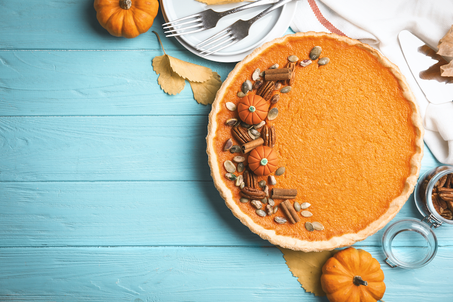 Delicious homemade pumpkin pie on light blue wooden table, flat lay.