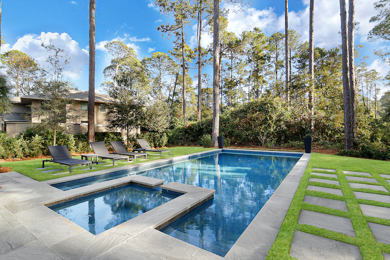 Backyard view of Long Cove home Versailles French pattern tiles pool deck by Year Round Pool Hilton Head Island