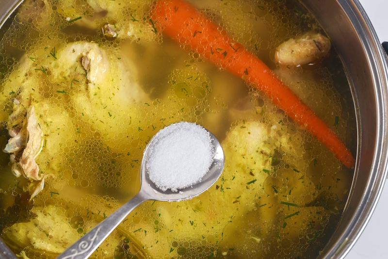 Kosher salt sprinkled over simmering soup pot