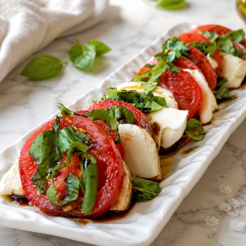 Tomato and mozzarella caprese salad served on platter