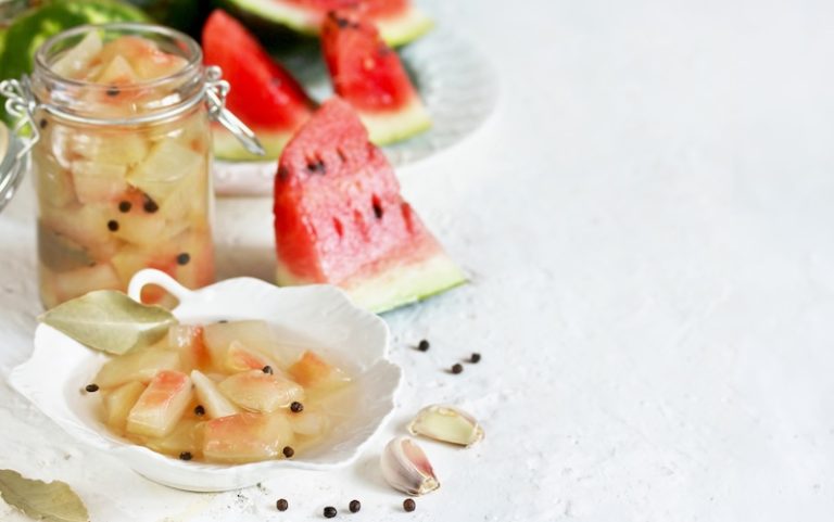 Homemade pickled watermelon rind in glass jar with peppercorns