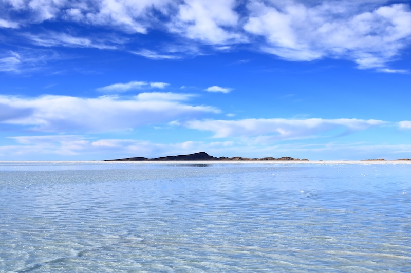 Mirror reflection across Salar de Uyuni salt flats in Bolivia