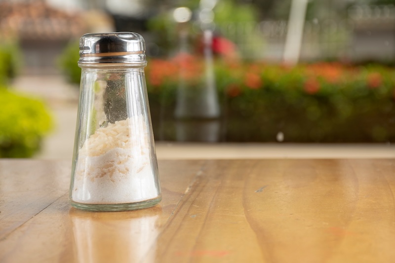 Salt shaker with rice grains to prevent clumping in humidity