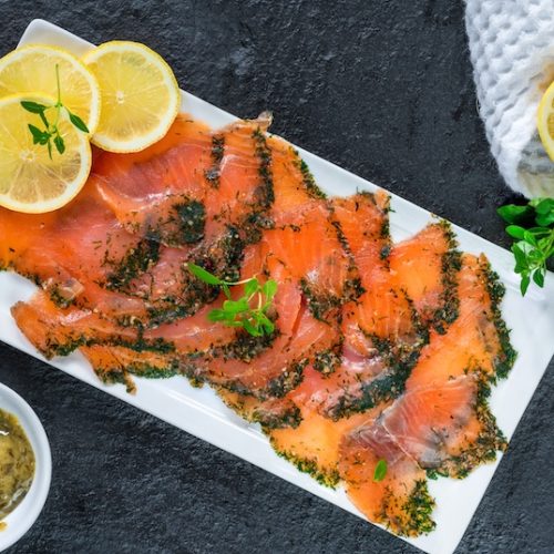 Thinly sliced salt-cured salmon gravlax with dill and lemon