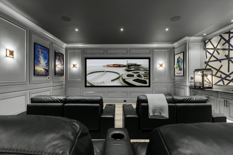 Tiered seating and a high-contrast 4K projection system for Luxury home theater by Fusion Audio and Video
