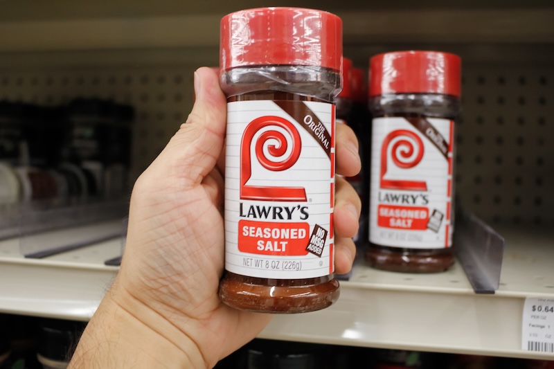 A view of a hand holding a container of Lawry's Seasoned Salt