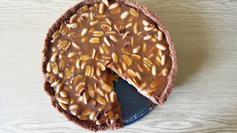 Cheesecake topped with caramel and roasted peanuts