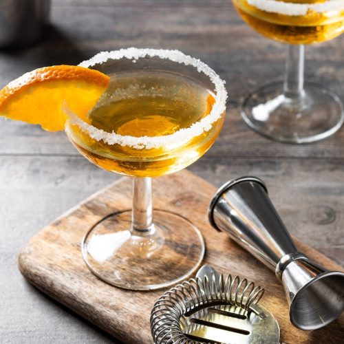 Sidecar cocktail with sugar rim and orange garnish beside Copper & Kings Butchertown Reserve Brandy