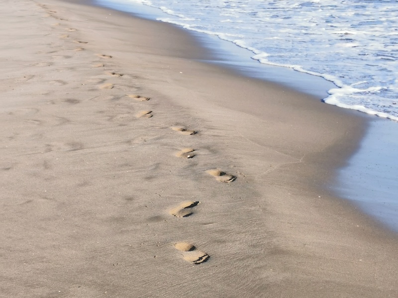 Footprints in the sand representing mindful walking meditation practice