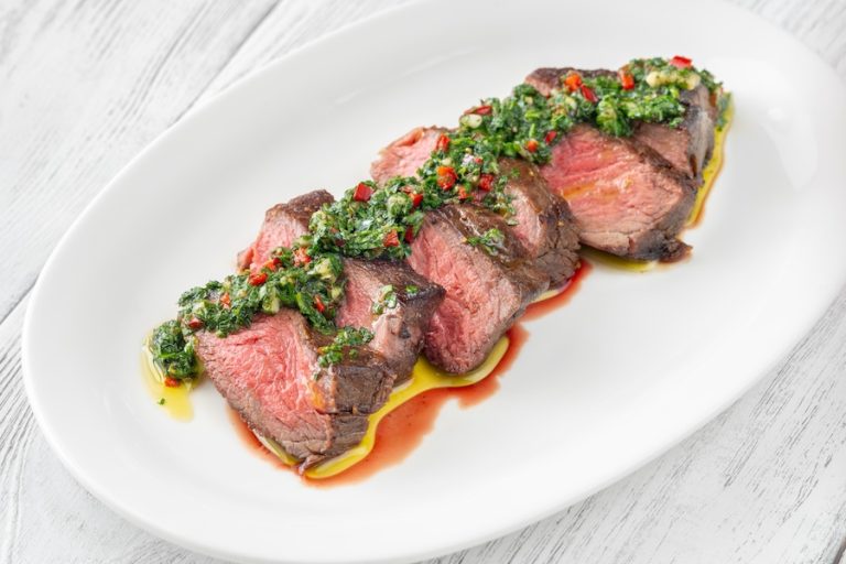 Grilled steak topped with chimichurri demonstrating how acidic flavors balance rich foods.
