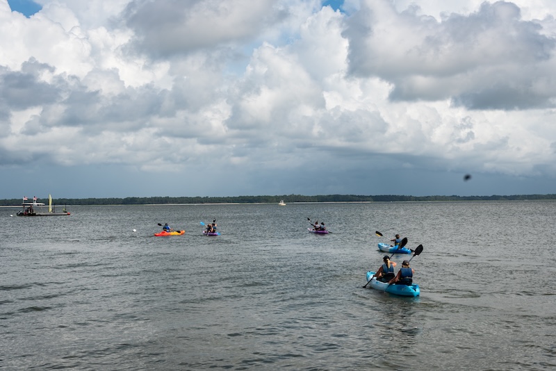Friends kayaking together through Broad Creek on Hilton Head Island.