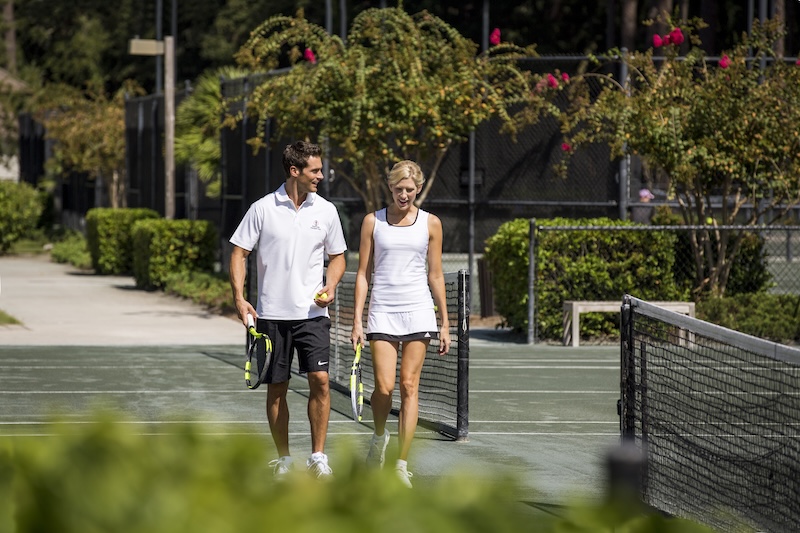 Friends playing doubles tennis at Sea Pines Racquet Club.