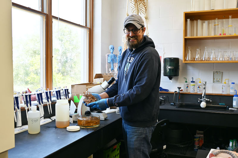 Brugler examines a soft coral specimen in his laboratory at the University of South Carolina Beaufort.