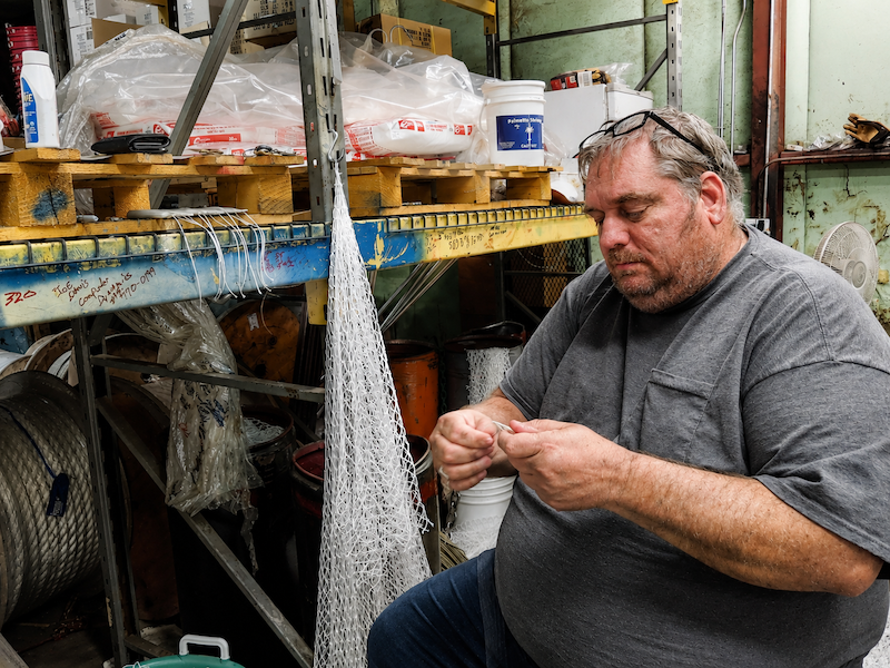 Scott Lettich of Beaufort Marine Supply stitching together a commercial shrimp trawl by hand.