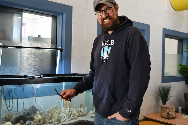 Dr. Mercer Brugler displays a preserved specimen of black coral from the deep-sea genus Leiopathes.