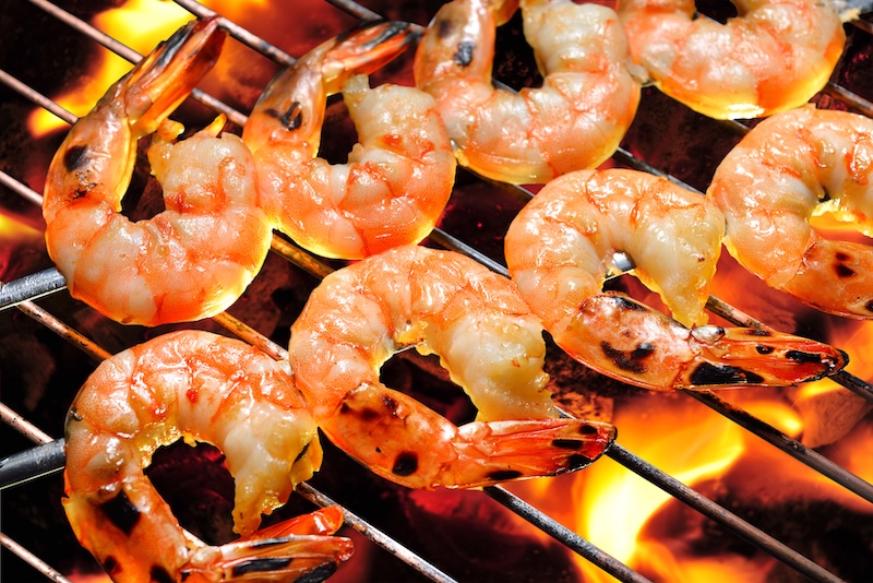 Shrimp cooking on a grill as a lighter alternative to fried or heavily breaded shrimp.