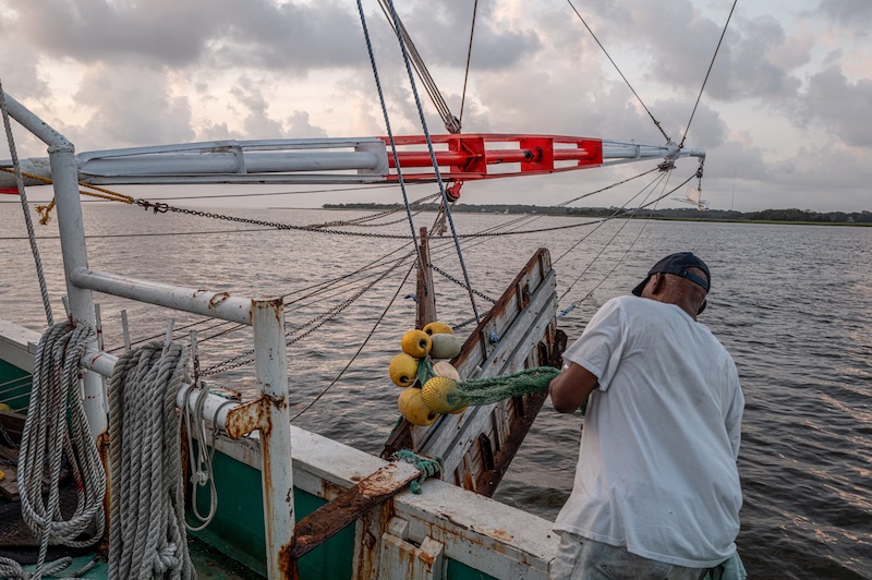 Gracie Belle crew hauling a commercial shrimp trawl back aboard after a tow.