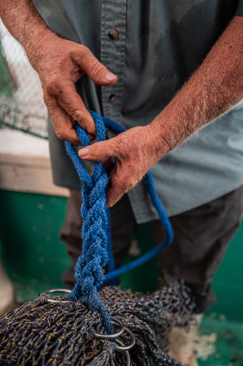 A Gracie Belle crew member handling fishing gear during a day of commercial shrimping.