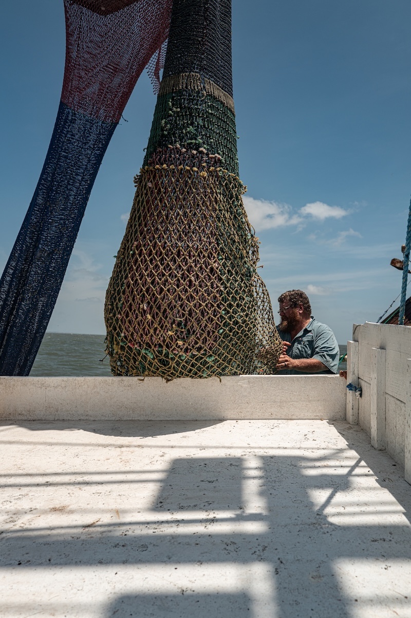 A full shrimp trawl bag being lifted above the deck of the Gracie Belle.