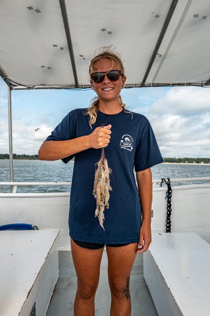 Ella Ridgeway holding marine life collected during research aboard the Tammy Jane shrimp trawler.