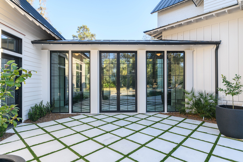 Outdoor surface in Palmetoo Bluff home glass passageway by Court Atkins Group