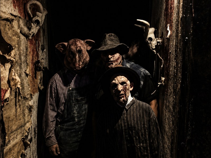 Costumed characters gathered in a dark haunted-house setting