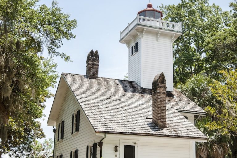 Historic white Haig Point Lighthouse surrounded by trees on Daufuskie Island