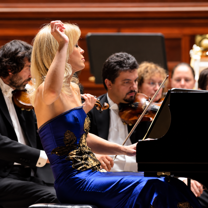 Olga Kern performing at the piano with an orchestra at Prague’s Smetana Hall