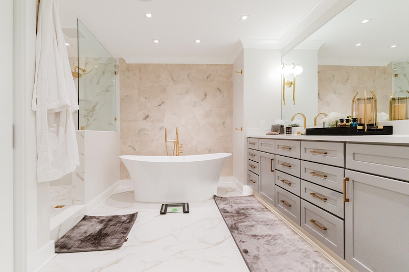 Light-filled bathroom with recessed ceiling fixtures and dedicated lighting at the vanity mirror