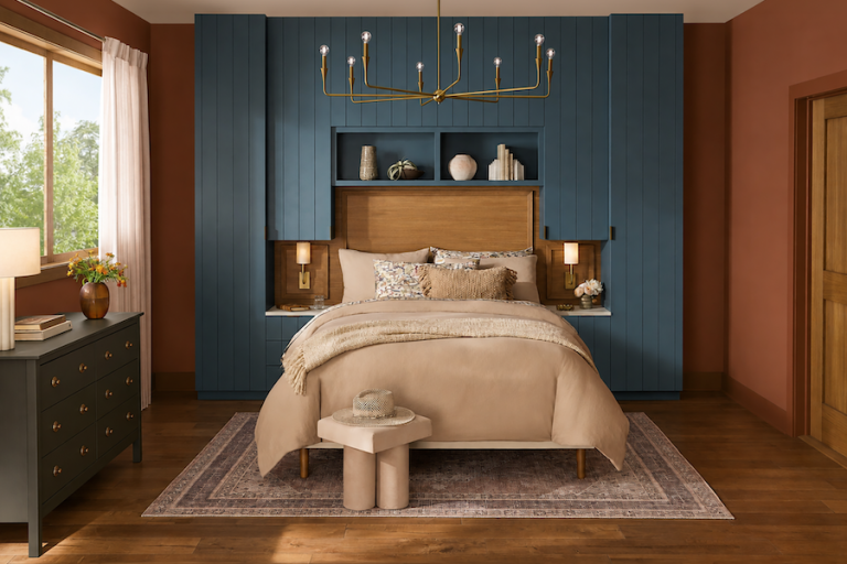 Cozy bedroom with burnished orange walls, deep blue floor-to-ceiling millwork, cream bedding and natural wood accents