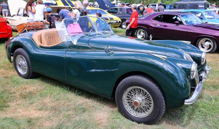 Classic green Jaguar XK roadster displayed at an automotive event