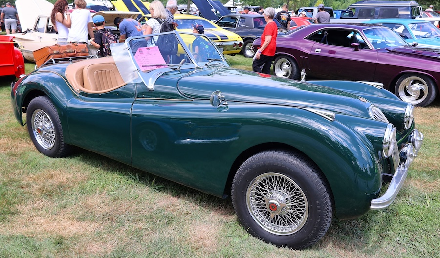 Classic green Jaguar XK roadster displayed at an automotive event