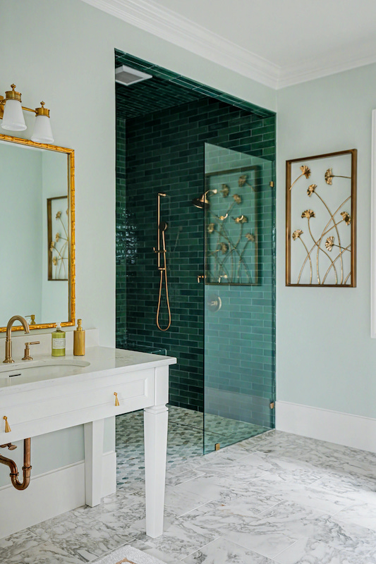 Light bathroom with a white vanity and green-tiled shower