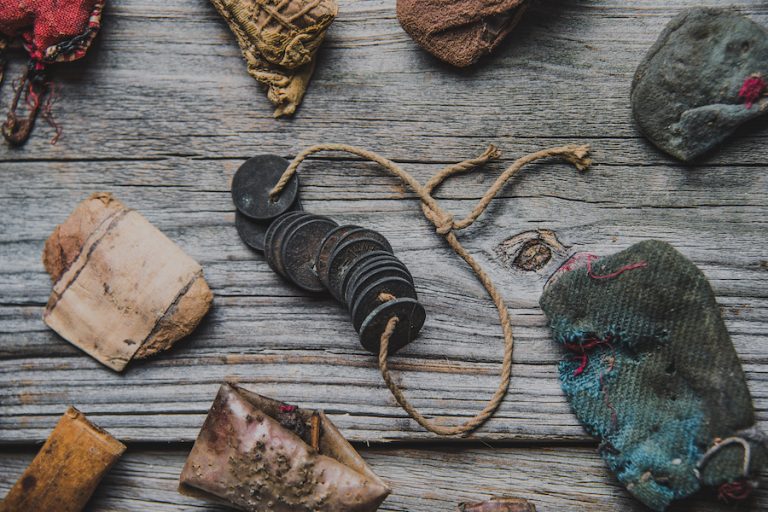 Rootwork charms, cloth bundles, roots and other objects arranged on a wooden surface