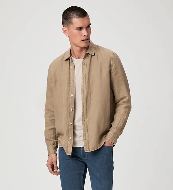Man wearing a lightweight tan button-down shirt with a white T-shirt and blue pants